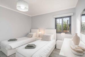 Sala de estar blanca con 2 camas y sofá en Villa Oceanscape, en Madalena do Mar 15 fotos más