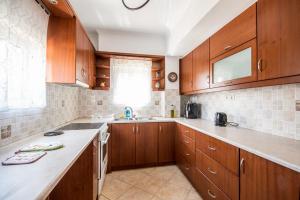 a large kitchen with wooden cabinets and a sink at Sea & Mountain Horizon by Myrto in Diakopto
