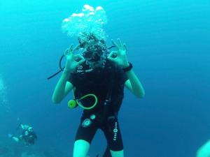 a woman in the water with her hands in the air at North Bali Beachhouse Ayu in Umeanyar
