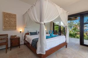 a bedroom with a bed with a canopy at North Bali Beachhouse Ayu in Umeanyar +84 photos