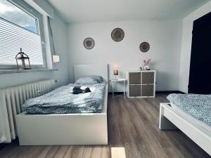 a bedroom with two beds and a window at Apartment OchtrUP I Ruhig & Geräumig in Ochtrup