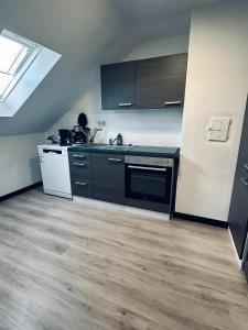 a kitchen with black and white appliances and wood floors at Apartment OchtrUP I Ruhig & Geräumig in Ochtrup