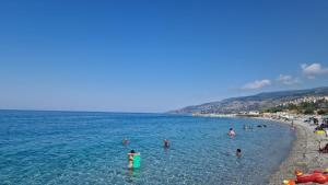 a group of people in the water at a beach at Tramonto sul Tirreno in Acquappesa
