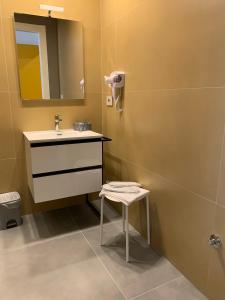 a bathroom with a sink and a stool and a mirror at B&B The Princess accanto all'Aeroporto di Salerno-Costa D'Amalfi in Bellizzi