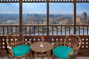 a balcony with a table and chairs and a view of the city at Cairo house in Cairo
