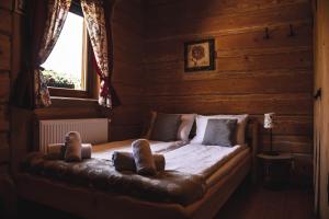 a bedroom with a bed in a log cabin at Chaty Wichrowe Wzgórze in Krynica Zdrój