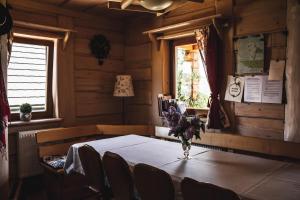 a dining room with a table with a vase of flowers on it at Chaty Wichrowe Wzgórze in Krynica Zdrój