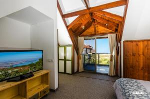 Schlafzimmer mit einem Flachbild-TV und einem Bett in der Unterkunft Beautiful Lake View Wooden House in Tiberias