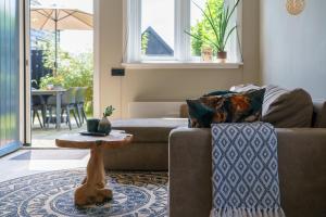 a living room with a couch and a table at De Juffer van Batinghe in Dwingeloo
