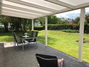 a patio with a table and chairs under a white pergola at Haus Am Spitalgarten für 10 Personen in Gundelfingen an der Donau