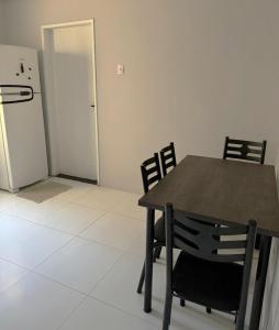 a kitchen with a table and chairs and a refrigerator at Casa Nunes in Aracaju