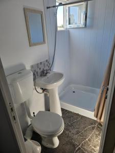 a bathroom with a toilet and a sink and a tub at Ca la noi acasă in Costinesti