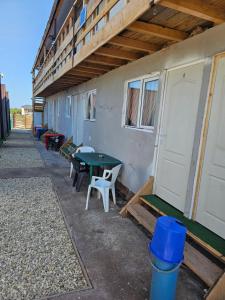 a patio with a table and chairs next to a building at Ca la noi acasă in Costinesti