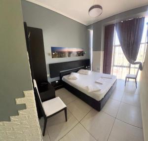 a bedroom with a bed and a chair in it at Hotel Rio in Lushnjë
