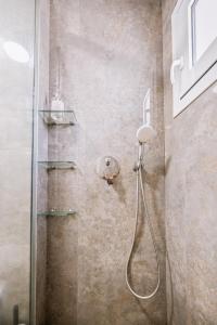 a shower with a glass door in a bathroom at CityView 2 fully equipped apt by Hospi in Heraklio Town