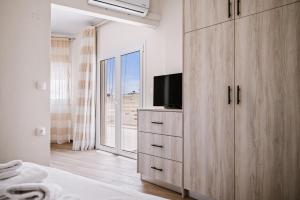 a bedroom with a large wooden cabinet with a television at CityView 2 fully equipped apt by Hospi in Heraklio Town