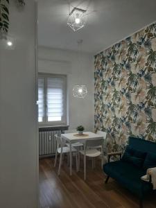 a dining room with a white table and a blue couch at Arona Lovely House in Arona