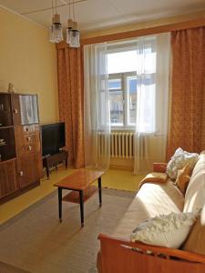 a living room with a couch and a tv at Nostalgic Retro Apartment in Kiviõli