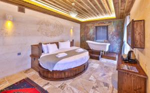 a bedroom with a bed and a tub and a sink at Noble Crown Stone House Cappadocia in Uchisar +161 photos