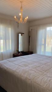 a bedroom with a large white bed and a chandelier at Espaço Vitali in Blinha