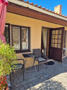Un patio con una mesa y sillas frente a una casa. en Villa Leonardo, en Ventspils