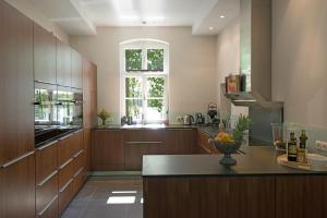 a large kitchen with wooden cabinets and a window at Herrenhaus Röddelin mit privater Badestelle in Templin