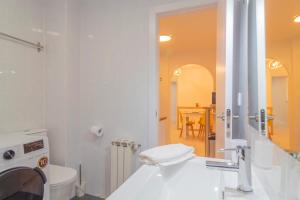 a white bathroom with a toilet and a sink at Apartamento Holidea Ayuntamiento de Santander in Santander +24 photos