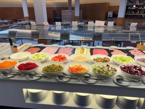 a buffet line with bowls of different types of food at Hotel Madeira Centro in Benidorm