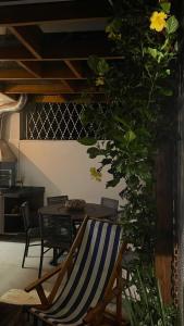 a room with a chair and a table with a plant at Casa na Praia de Santiago, próxima a Maresias! in São Sebastião