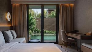 Una habitación de hotel con una cama, un escritorio y una ventana. en The Akasha Canggu Hotel, en Canggu 24 fotos más
