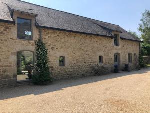 吉代勒La maison de Nati的一座石头建筑,前面有一棵树