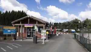 a small building with a sign in a parking lot at Camping Les Nysades in Mirepoix