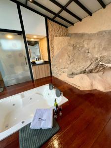 a bath tub in a room with a rock wall at VIP Glamping Ruitoque, Hermosa Vista in Floridablanca