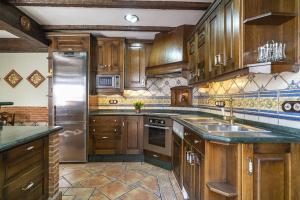 kuchnia z drewnianymi szafkami i lodówką ze stali nierdzewnej w obiekcie Casa con patio y terraza en Barrio histórico de la Villa, junto al Adarve w mieście Priego de Córdoba +21 zdjęć