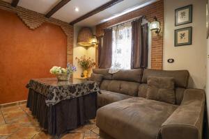 salon z kanapą i stołem w obiekcie Casa con patio y terraza en Barrio histórico de la Villa, junto al Adarve w mieście Priego de Córdoba