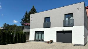 a large white house with two garage doors at City Apartments in Liptovský Mikuláš