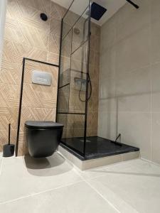 y baño con aseo negro y ducha. en MC Suite Briand CMZ Place-Ducale, en Charleville-Mézières