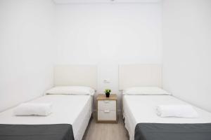 Łóżko lub łóżka w pokoju w obiekcie Apartamentos Marina Playa de Torrevieja by Apartamentos Torrevieja
