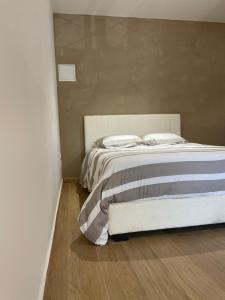 Cama blanca en habitación con suelo de madera en MC Suite Briand CMZ Place-Ducale, en Charleville-Mézières