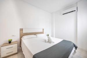 Łóżko lub łóżka w pokoju w obiekcie Apartamentos Marina Playa de Torrevieja by Apartamentos Torrevieja