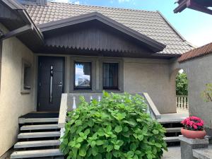 a house with stairs and a plant in front of it at Lampėdis in Kaunas