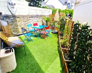 a patio with chairs and a table on grass at Ty West in Batz-sur-Mer