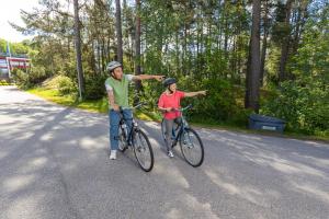 a man and a woman riding bikes down a road at Hostel Linnasmäki in Turku