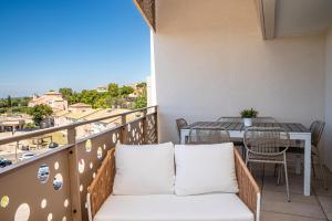 a balcony with a couch and a table and chairs at Sete, Thau Indigo B402 in Sète