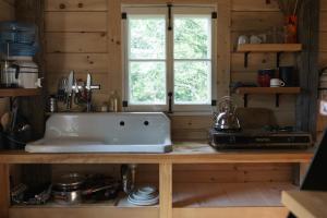 a kitchen counter with a white sink in a kitchen at Les Cabines St-O #2 in Saint-Onésime