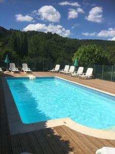 a large swimming pool with lounge chairs at Les Girouteaux La bergerie in Les Eyzies-de-Tayac