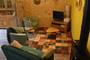 a living room with a couch and a tv at Les Girouteaux La bergerie in Les Eyzies-de-Tayac +14 photos