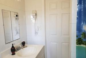 a white bathroom with a sink and a mirror at Coco Sol 2 by MyMiamiStay in Miami