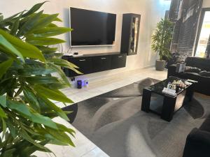 a living room with a tv and a couch and a table at Luxury 2- Apartment Furnished luxury residence in Cocody