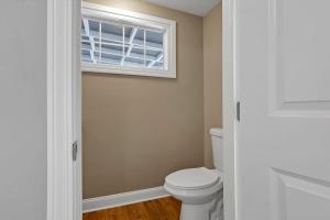 a bathroom with a toilet and a window at The Huron Charmer-4 BD and Yard in Columbus
